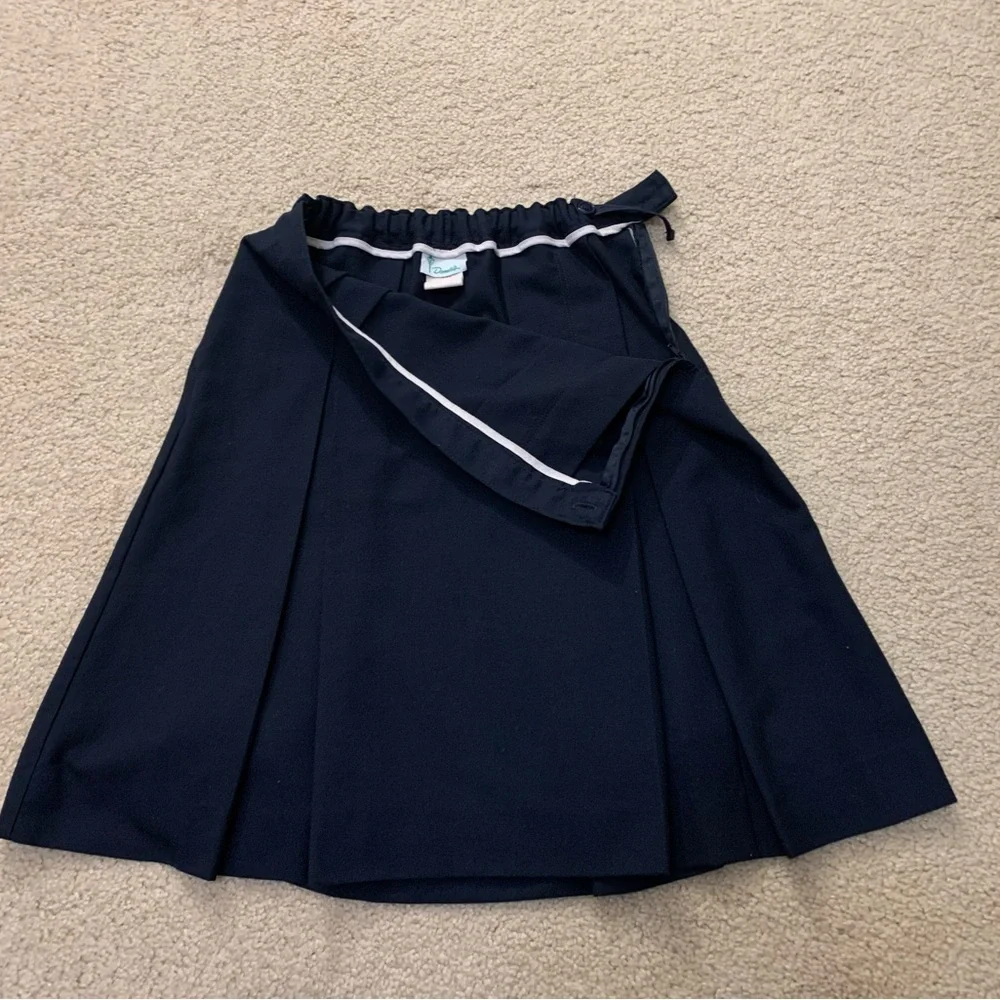 Navy blue pleated skirt with adjustable waist.